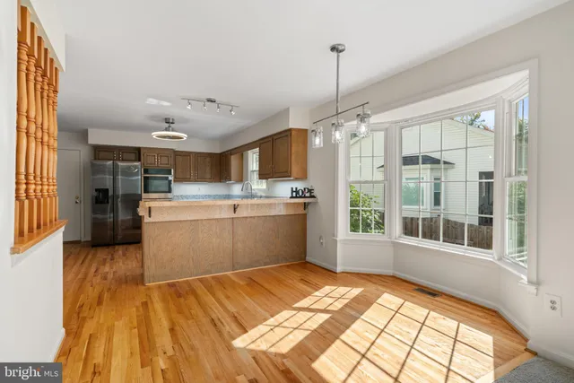a view of a kitchen with kitchen island a sink a counter top space and stainless steel appliances