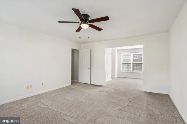 a view of an empty room with a ceiling fan
