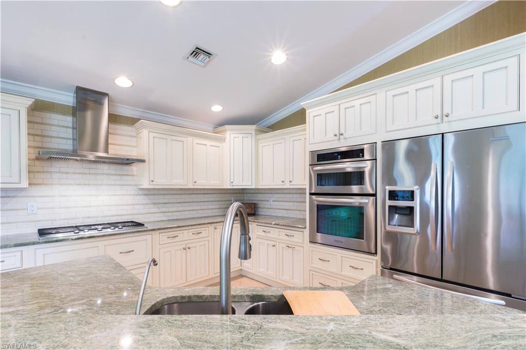 19741 Villa Rosa Loop Estero, FL 33967 - Photo 8 of 21 a kitchen with stainless steel appliances kitchen island granite countertop a refrigerator a stove and a sink