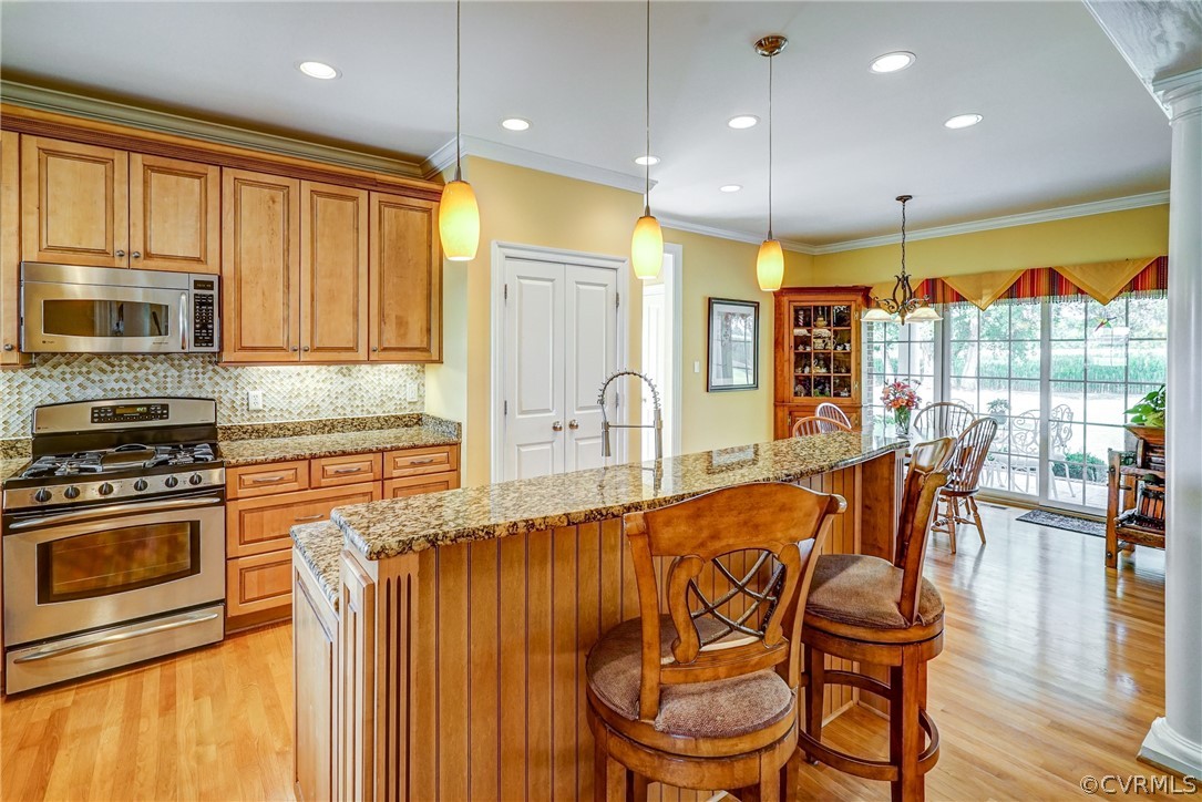 11351 Hillcrest Road Hanover, VA 23069 - Photo 15 of 48 a kitchen with stainless steel appliances granite countertop a stove a refrigerator a kitchen island with a dining table and chairs