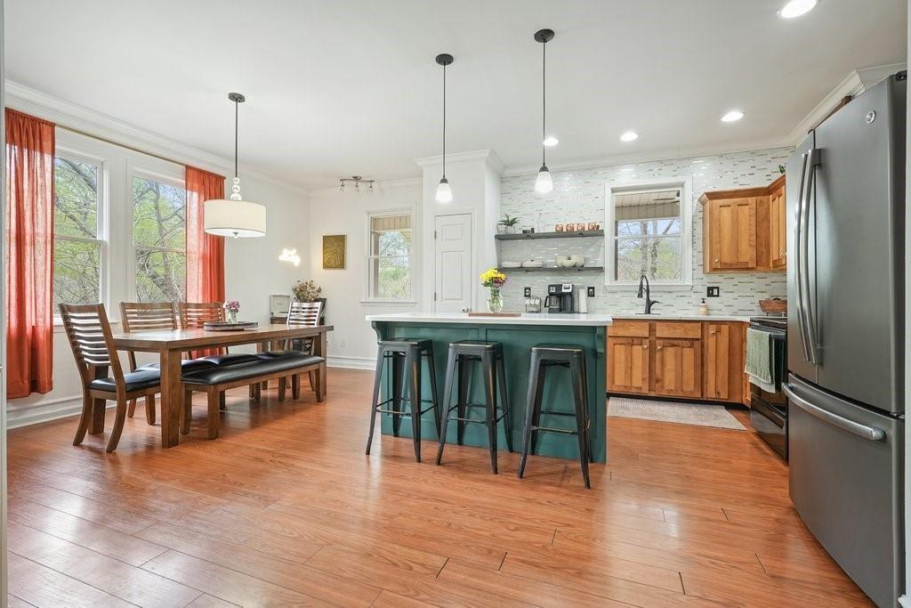 2232 Burnt Mountain Road Jasper, GA 30143 - Photo 16 of 50 a kitchen with stainless steel appliances granite countertop a stove top oven a sink dishwasher and a dining table with wooden floor