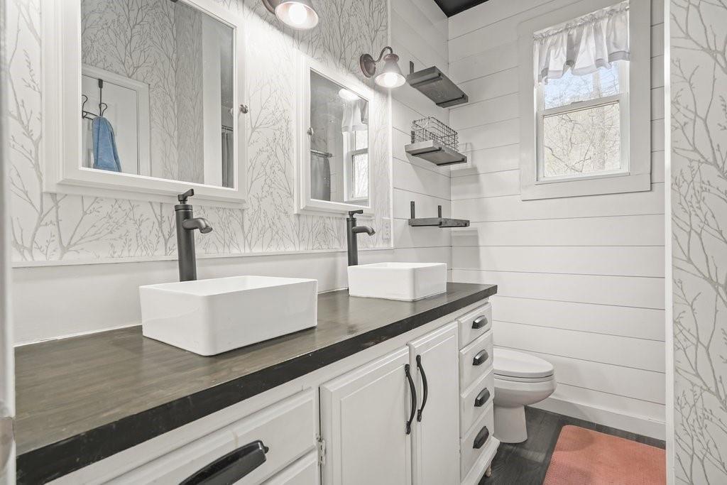 2232 Burnt Mountain Road Jasper, GA 30143 - Photo 33 of 50 a bathroom with a granite countertop sink a toilet a vanity and mirror