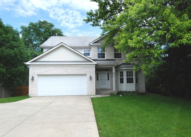 a front view of a house with a garden and yard