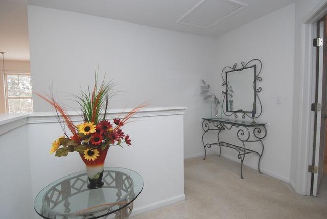 231 South Quentin Road Palatine, IL 60067 - Photo 6 of 10 a vase of flowers sitting on a table with a mirror