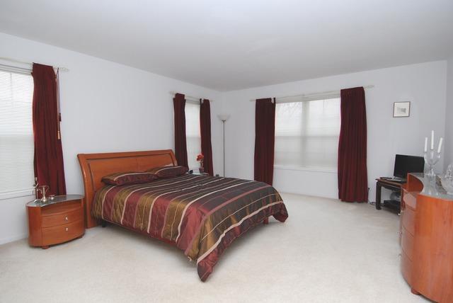 231 South Quentin Road Palatine, IL 60067 - Photo 7 of 10 a bedroom with a bed and a flat tv screen on dresser