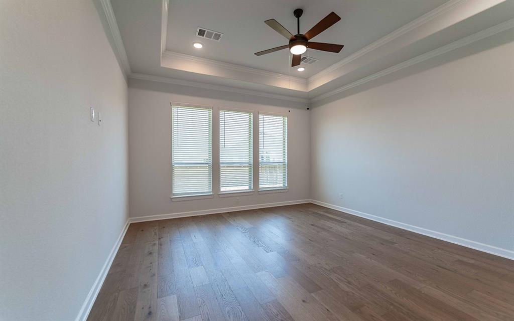 2008 Casting Ridge Mesquite, TX 75181 - Photo 14 of 24 Spacious room featuring wood-finish flooring, a tiered tray ceiling with recessed lighting, and a ceiling fan