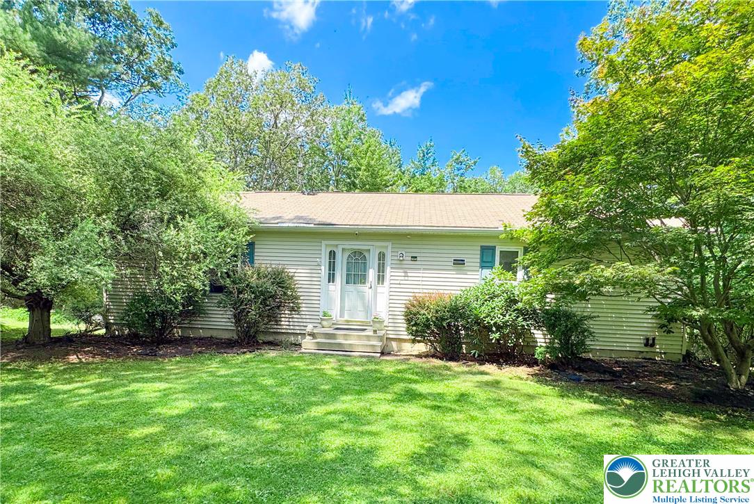 a view of a house with a yard and potted plants