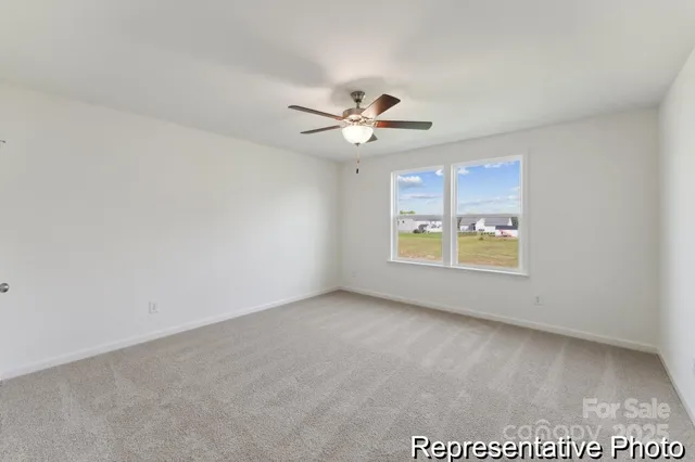 an empty room with windows and ceiling fan