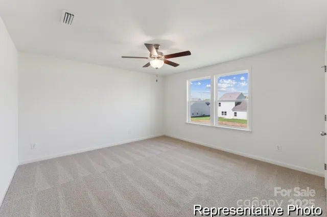 an empty room with windows and ceiling fan