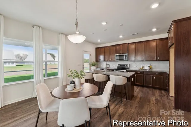 a kitchen with stainless steel appliances granite countertop a kitchen island hardwood floor sink and stove
