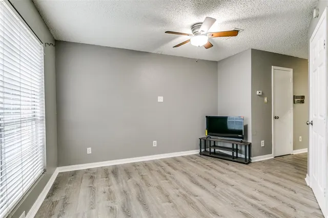 a view of room with wooden floor and ceiling fan