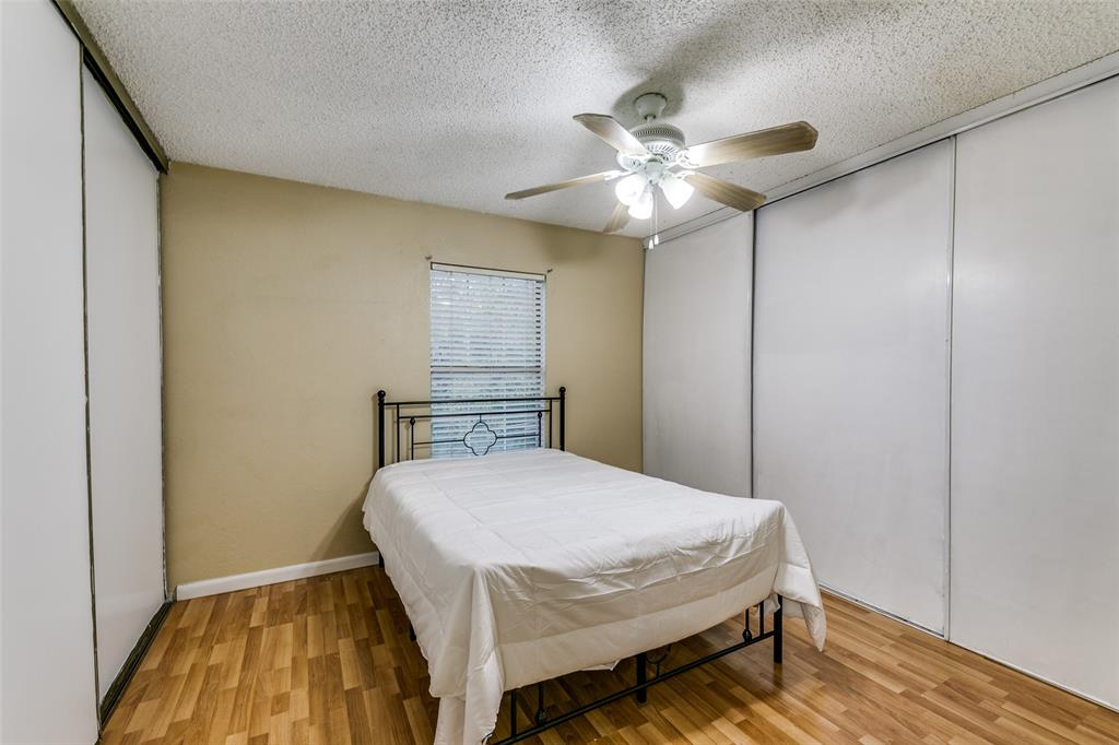 2400 Jupiter Road, Unit 2 Plano, TX 75074 - Photo 9 of 18 a bedroom with a bed and a chandelier