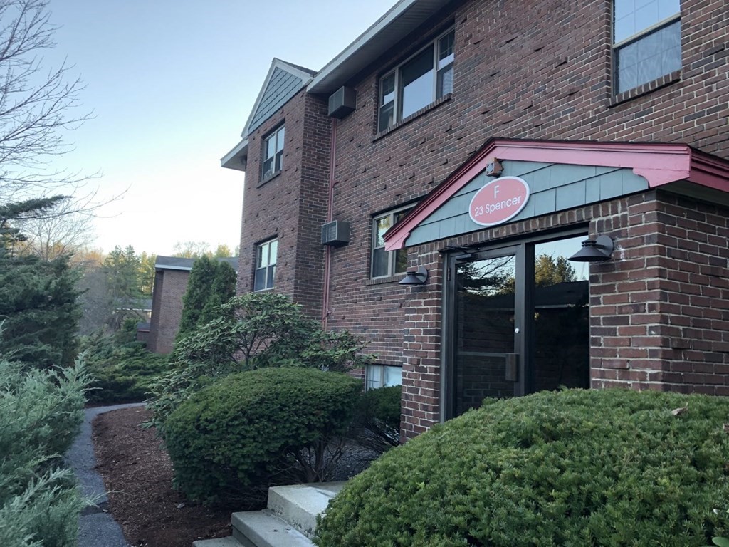 23 Spencer Road, Unit 22F Boxborough, MA 01719 - Photo 1 of 10 a view of a brick building with a small yard and plants