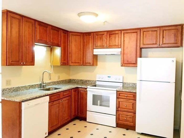 23 Spencer Road, Unit 22F Boxborough, MA 01719 - Photo 2 of 10 a kitchen with granite countertop a sink a stove a refrigerator and cabinets