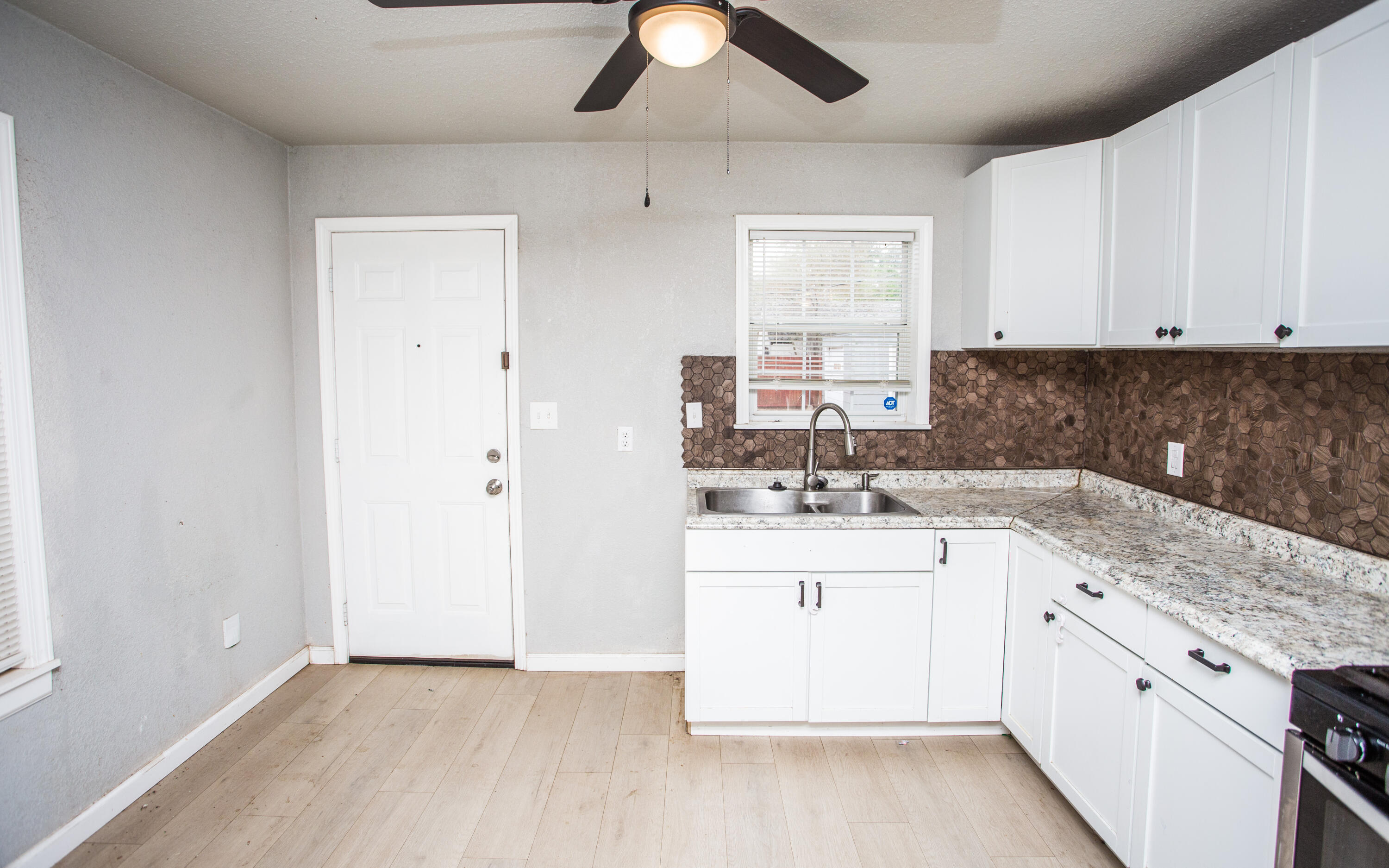 1518 40th Street Lubbock, TX 79412 - Photo 2 of 13 a kitchen with a sink stove and cabinets