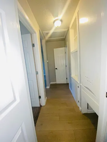a view of a hallway with wooden floor and staircase