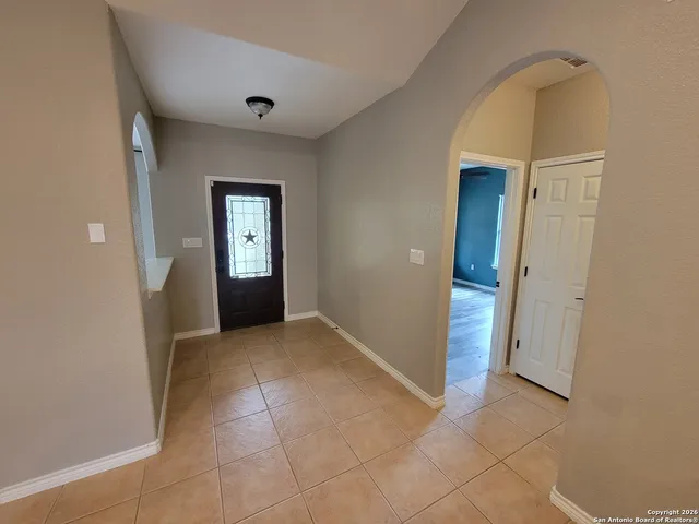 a view of an empty room with a fireplace and a window