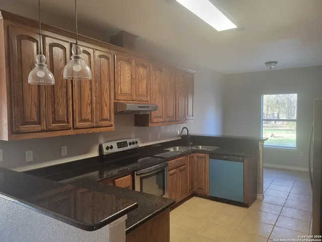 a kitchen with stainless steel appliances granite countertop a sink stove and cabinets