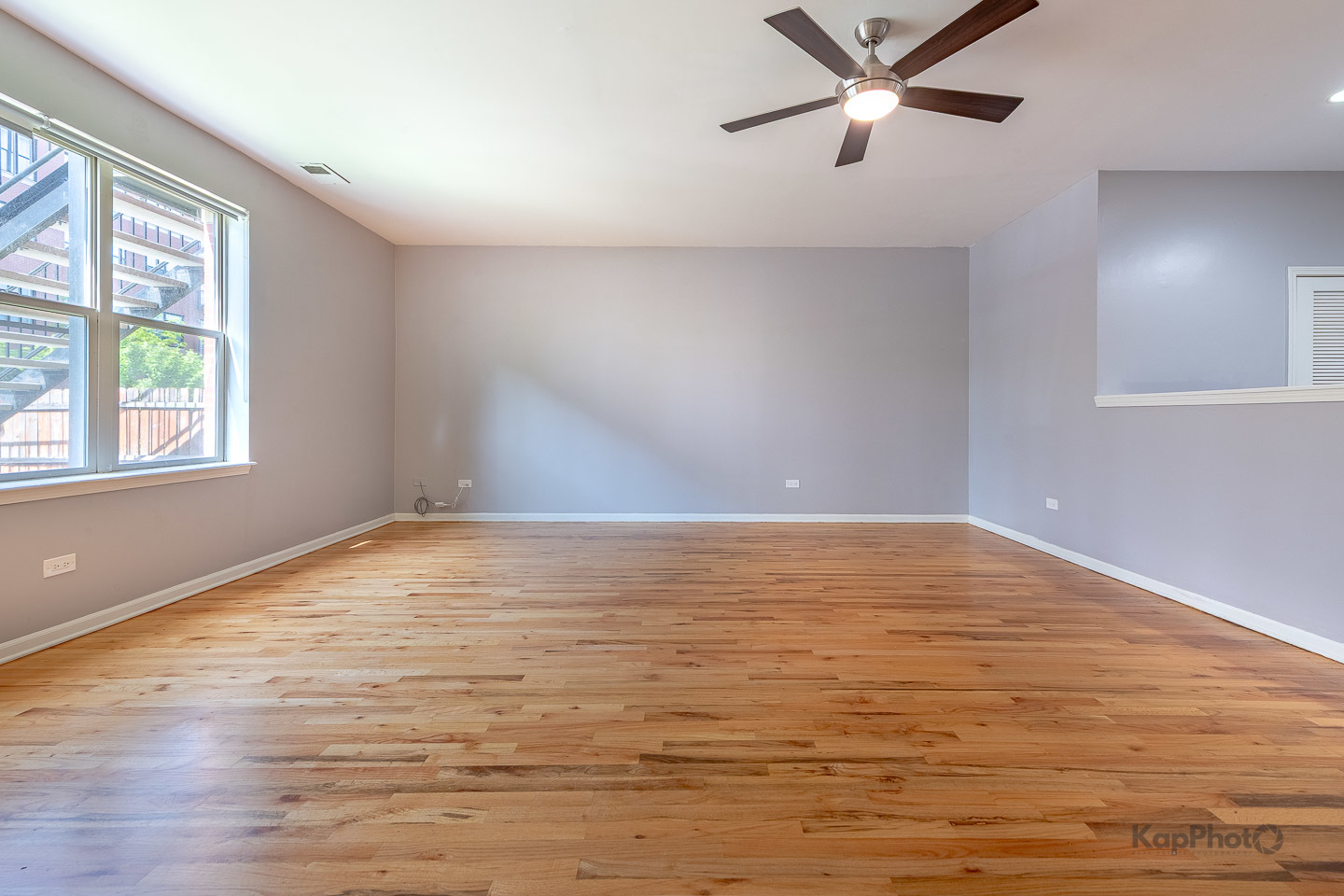 2142 West Madison Street, Unit 1 Chicago, IL 60612 - Photo 7 of 27 an empty room with wooden floor fan and windows