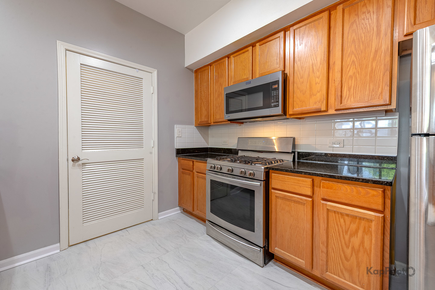 2142 West Madison Street, Unit 1 Chicago, IL 60612 - Photo 9 of 27 a kitchen with stainless steel appliances granite countertop a stove microwave and sink