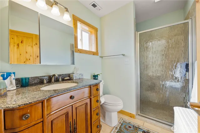 a bathroom with a granite countertop sink toilet and shower