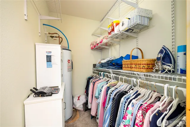 a view of walk in closet with clothes and shoes