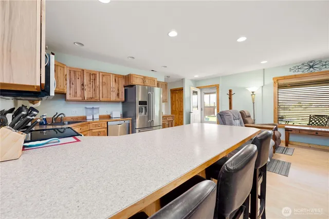 a living room with stainless steel appliances furniture a kitchen view living room and a window