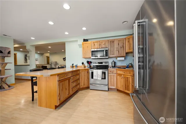 a kitchen with stainless steel appliances kitchen island granite countertop a refrigerator and a stove top oven