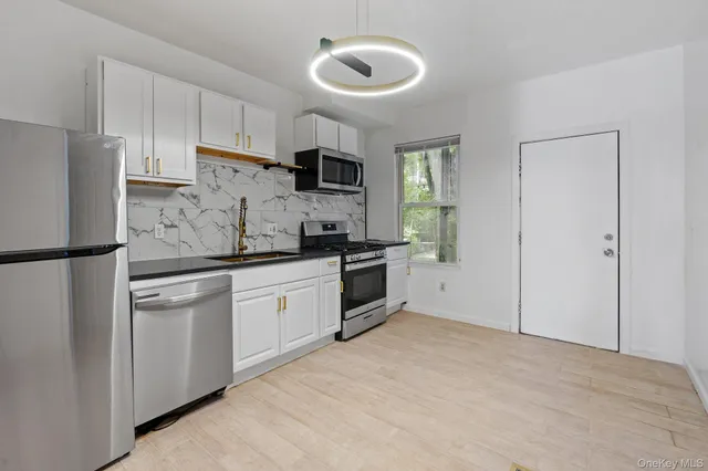a kitchen with white cabinets and stainless steel appliances