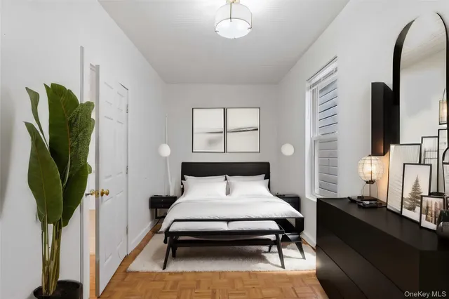a bedroom with a bed table and a flat screen tv