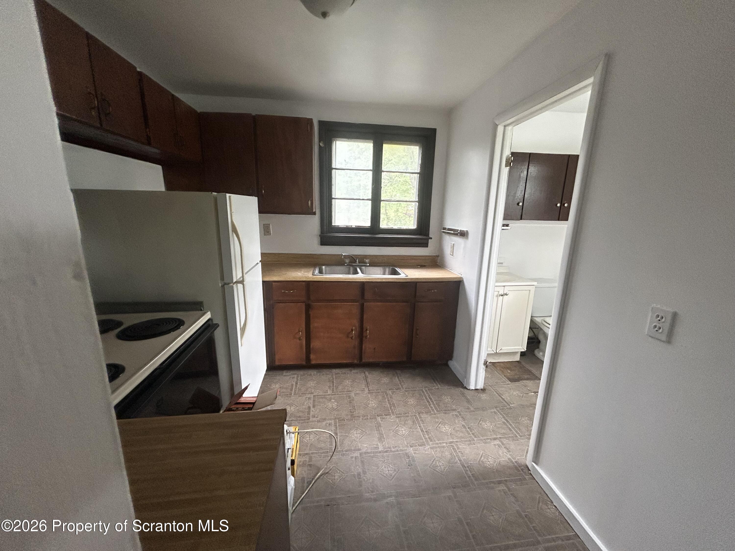 717 East Elm Street, Unit REAR Scranton, PA 18505 - Photo 5 of 9 a kitchen with stainless steel appliances a refrigerator and a sink