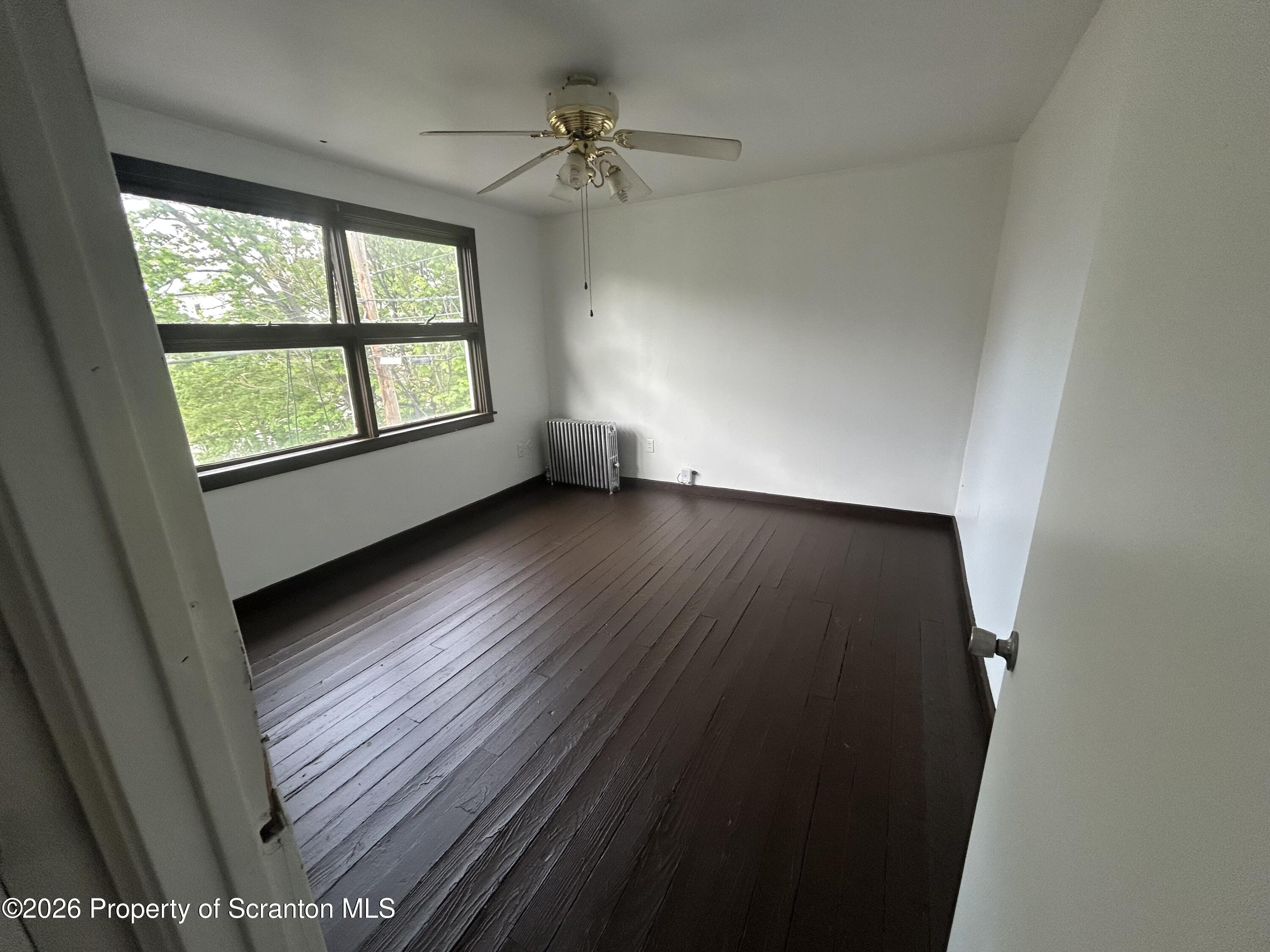 717 East Elm Street, Unit REAR Scranton, PA 18505 - Photo 7 of 9 an empty room with wooden floor fan and windows