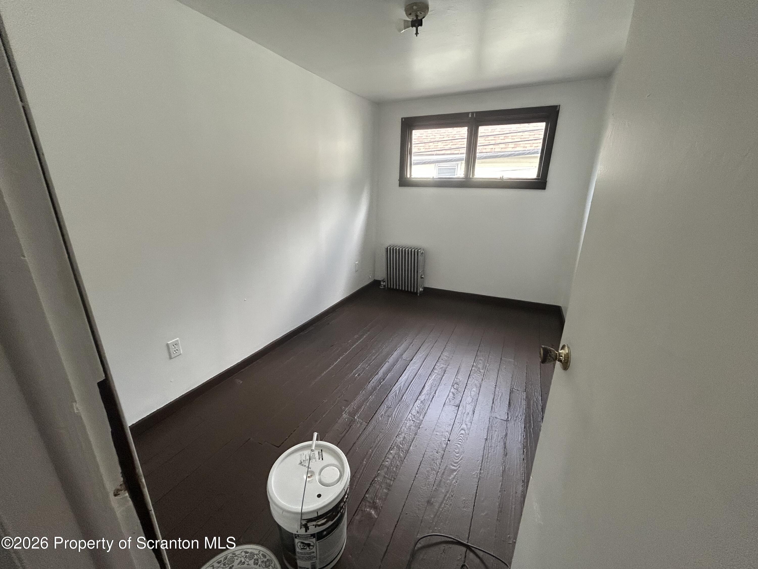 717 East Elm Street, Unit REAR Scranton, PA 18505 - Photo 8 of 9 an empty room with wooden floor and windows