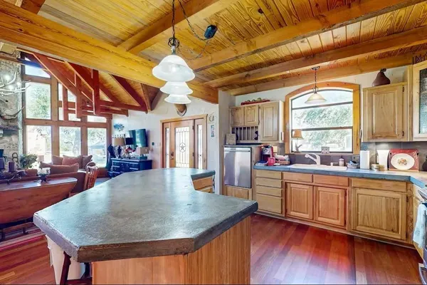 a kitchen with stainless steel appliances granite countertop a sink a stove cabinets counter space and a large window