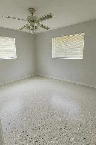 an empty room with a chandelier fan