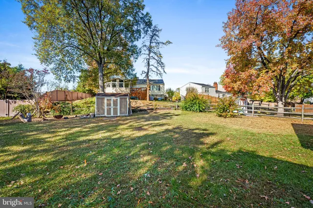 a view of a house with a big yard and large trees