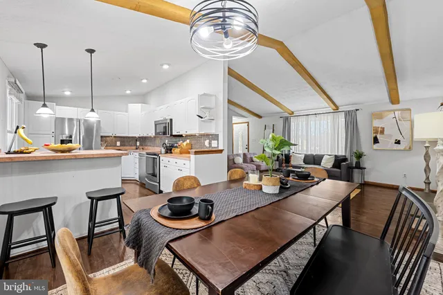 a kitchen with a table chairs and white cabinets