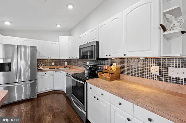 a kitchen with granite countertop a refrigerator stove and sink
