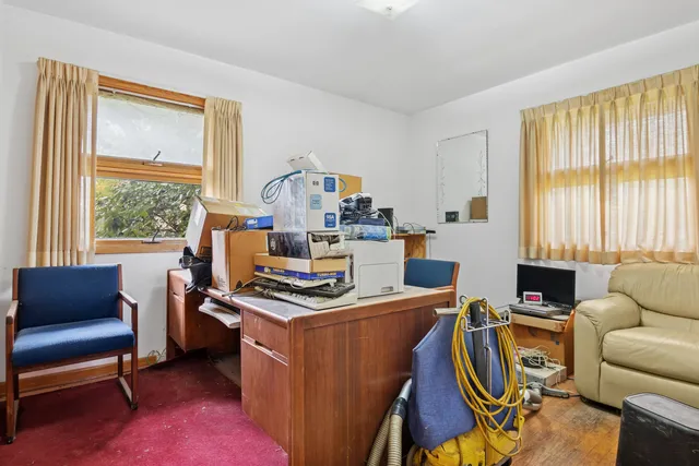 a work room with furniture a flat screen tv and a window