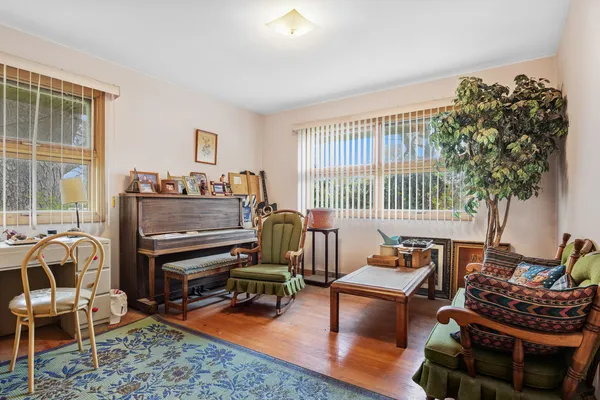 a living room with furniture a piano and a potted plant