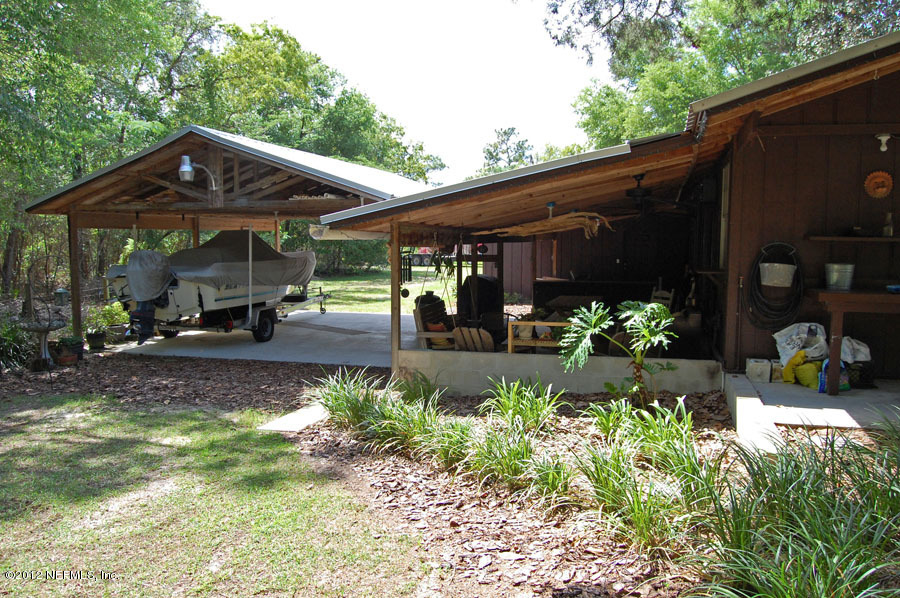 6675 Brooklyn Bay Road Keystone Heights, FL 32656 - Photo 6 of 16 a view of a chair and tables in the backyard of the house