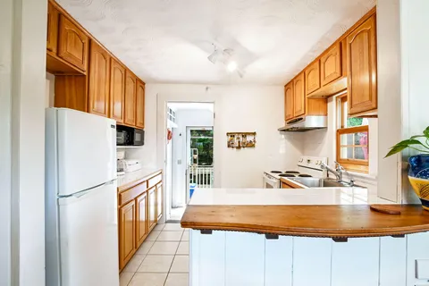 a kitchen with stainless steel appliances granite countertop a refrigerator a stove and a sink with wooden floor