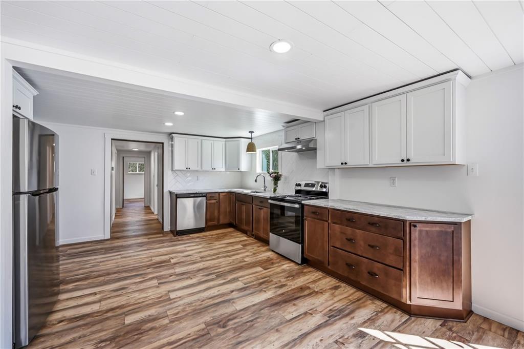 311 Oakdale Road Darlington, PA 16115 - Photo 17 of 32 a kitchen with stainless steel appliances granite countertop a stove top oven a sink dishwasher a refrigerator and white cabinets with wooden floor