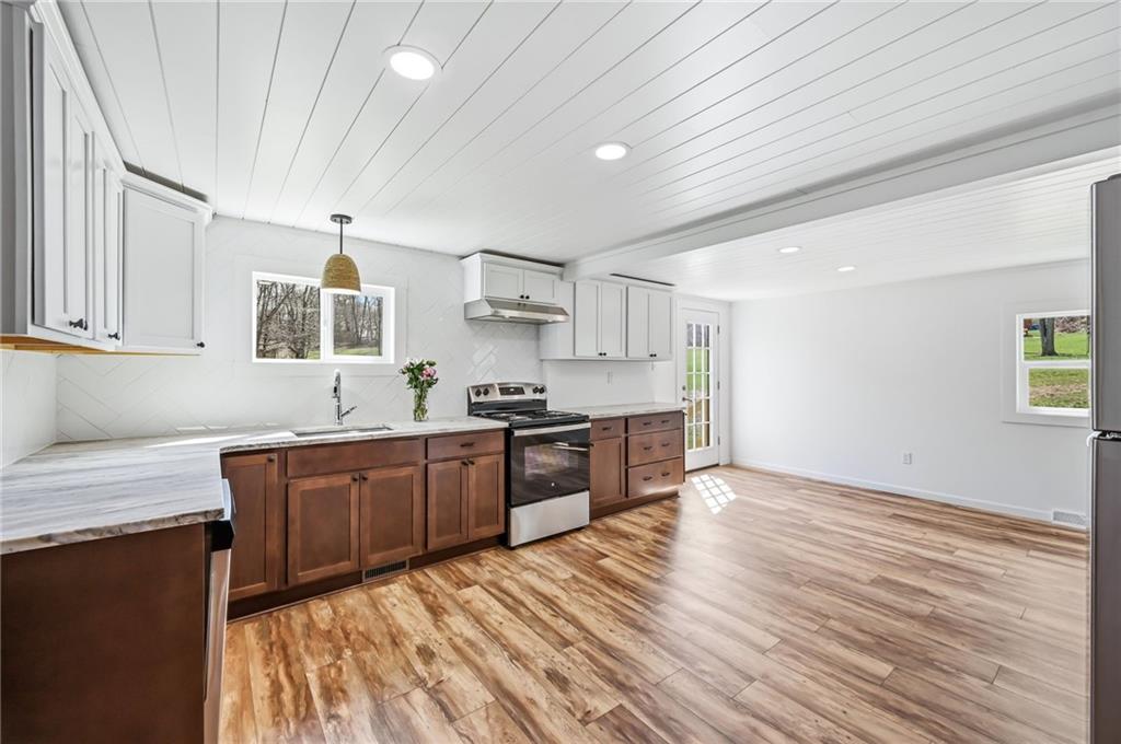 311 Oakdale Road Darlington, PA 16115 - Photo 18 of 32 a large kitchen with stainless steel appliances granite countertop a lot of counter space and wooden floors