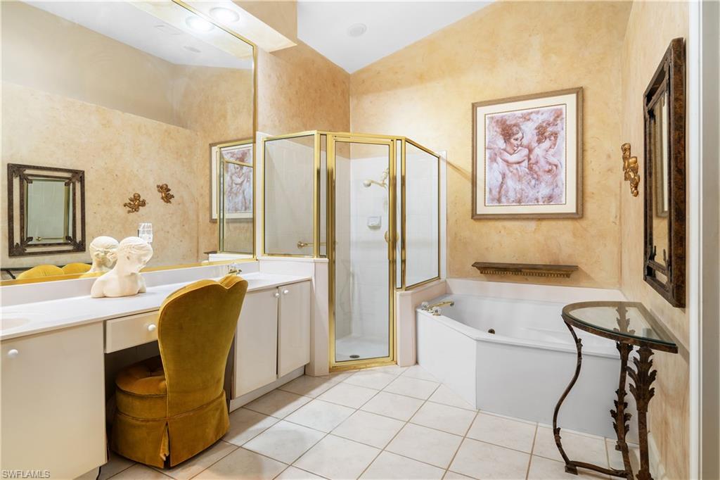 2399 Northwest 24th Street Boca Raton, FL 33434 - Photo 12 of 23 Primary Bathroom featuring tile patterned flooring, vanity, vaulted ceiling, and plus walk in shower