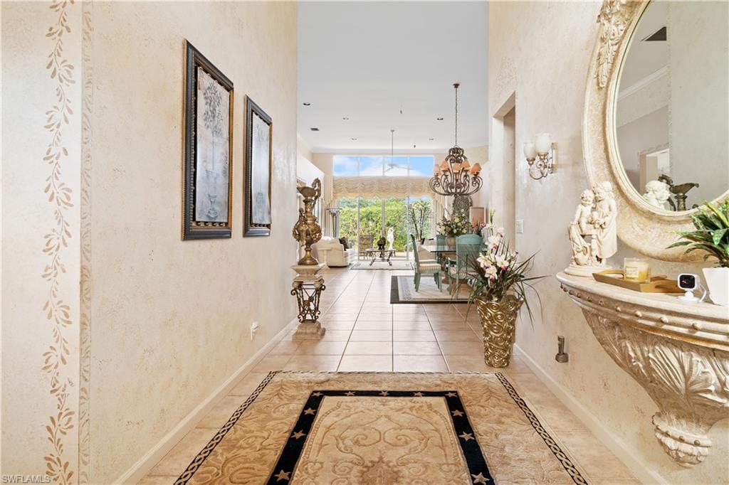 2399 Northwest 24th Street Boca Raton, FL 33434 - Photo 2 of 23 Hall with tile patterned flooring and a chandelier