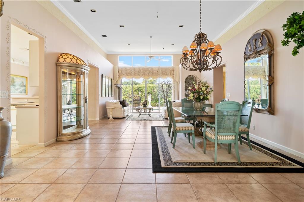 2399 Northwest 24th Street Boca Raton, FL 33434 - Photo 3 of 23 Tiled dining space with crown molding and a chandelier