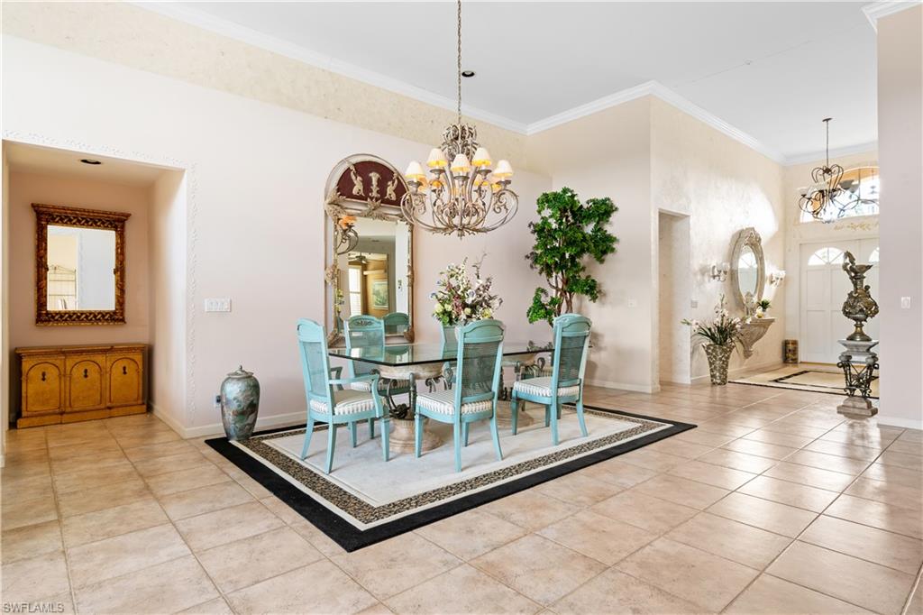 2399 Northwest 24th Street Boca Raton, FL 33434 - Photo 5 of 23 Dining area featuring a notable chandelier, light tile patterned floors, and crown molding