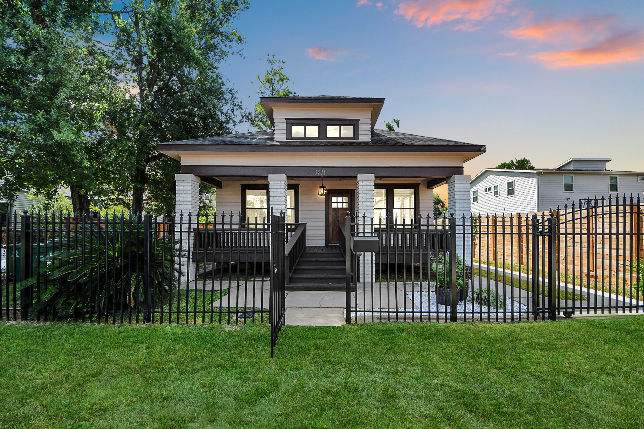 1211 Bingham Street Houston, TX 77007 - Photo 2 of 48 a front view of a house with a garden and yard