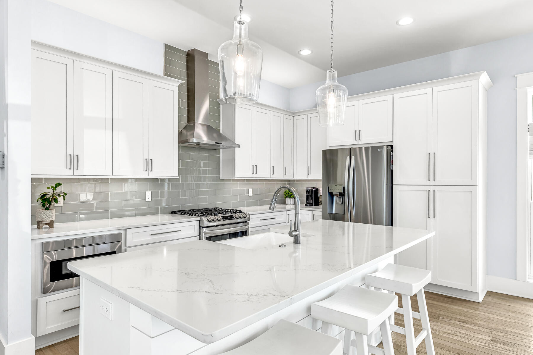 56 Cypress Drive Santa Rosa Beach, FL 32459 - Photo 11 of 61 a kitchen with stainless steel appliances kitchen island granite countertop a refrigerator a sink a stove and white cabinets with wooden floor